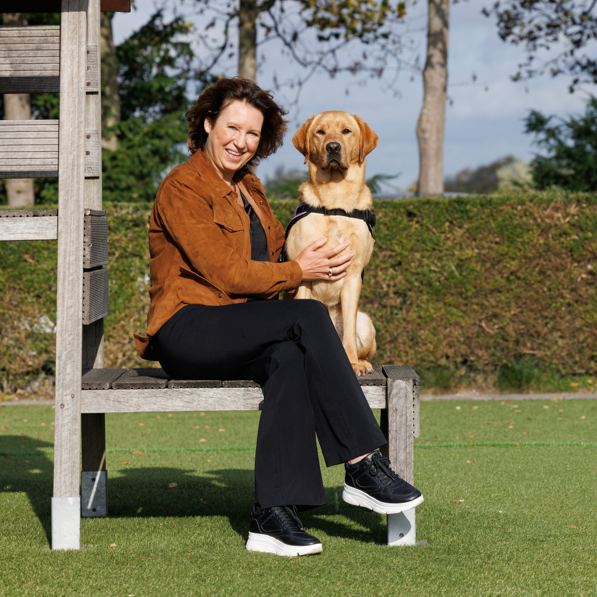 vrouw zit buiten met hond naast haar